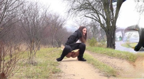 Nicolette Noir squats for a badly needed pee while walking on a dirt path