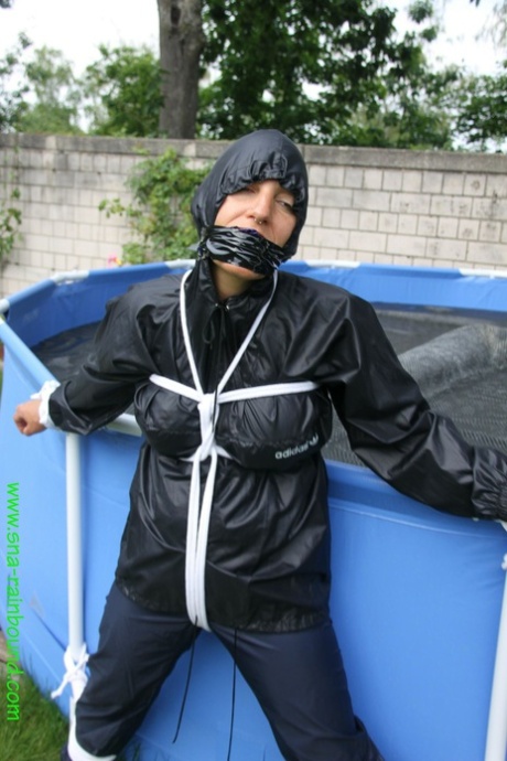 业余女子桑德拉被堵住嘴，穿着雨衣被绑在水池上