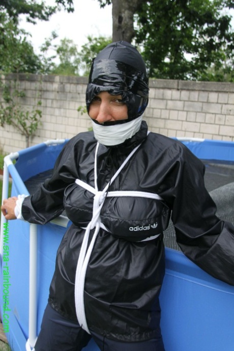 业余女子桑德拉被堵住嘴，穿着雨衣被绑在水池上