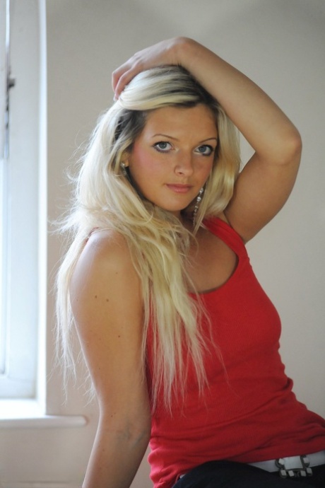 Hübsche blonde Zuzia wird völlig nackt auf einem Holzstamm in einem Schlafzimmer