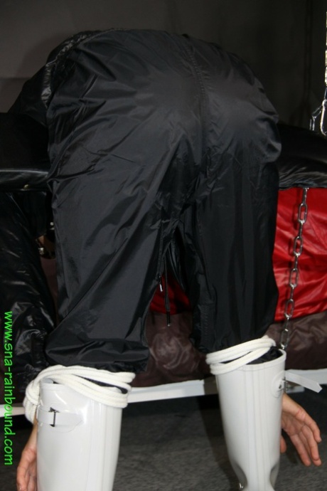 White chick in rainwear is left restrained in a uncomfortable position