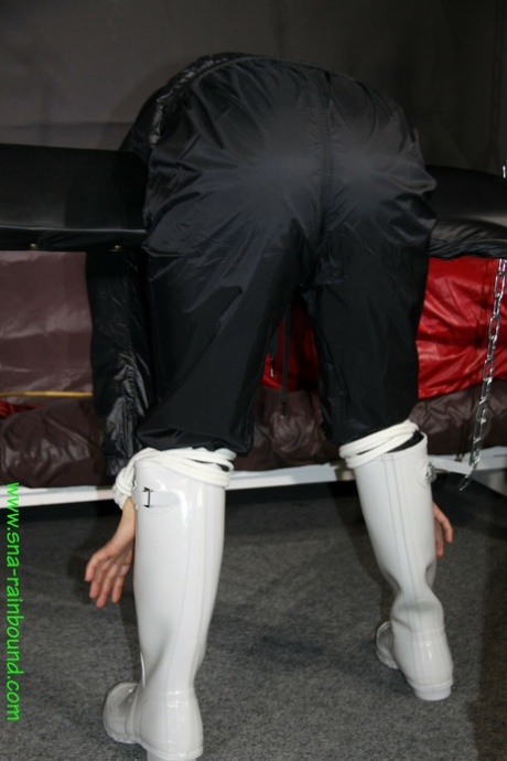 White chick in rainwear is left restrained in a uncomfortable position