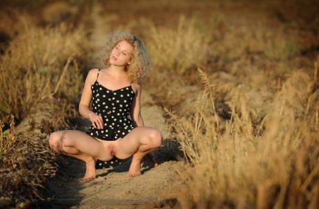 Blonde teen Helena exposes herself in a field of sunflowers while at a farm