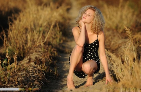 Blonde teen Helena exposes herself in a field of sunflowers while at a farm