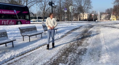 白人女孩朱丽娅白天在白雪覆盖的小路上小便