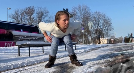 白人女孩朱丽娅白天在白雪覆盖的小路上小便