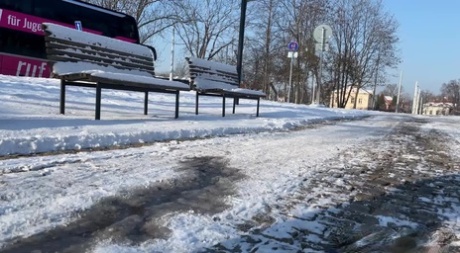 白人女孩朱丽娅白天在白雪覆盖的小路上小便