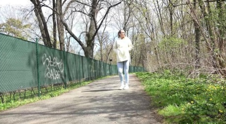 Blonde girl Bianca pulls down sweatpants to pee on a paved walking path