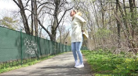 Blonde girl Bianca pulls down sweatpants to pee on a paved walking path