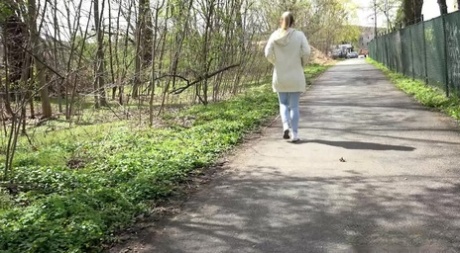 Blonde girl Bianca pulls down sweatpants to pee on a paved walking path