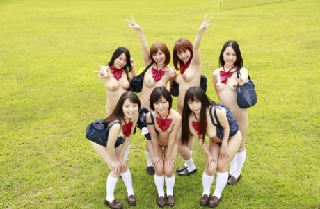 A group of Japanese girls pose nude in a field in white socks