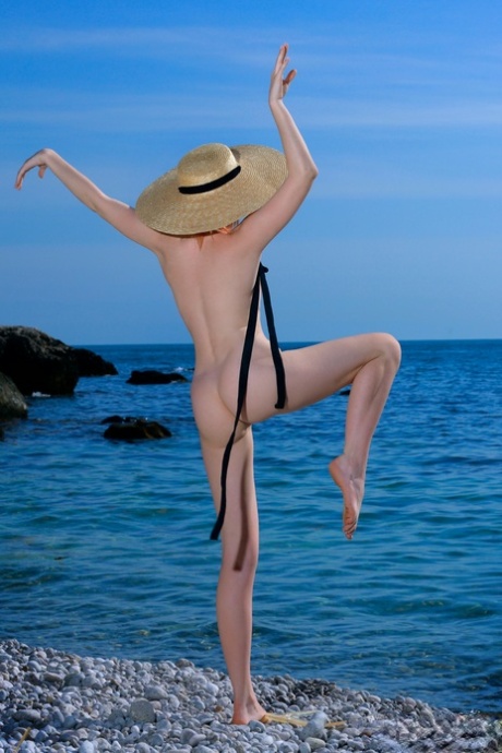 Charming teen Nikol takes off swimwear to go nude on a pebbly beach