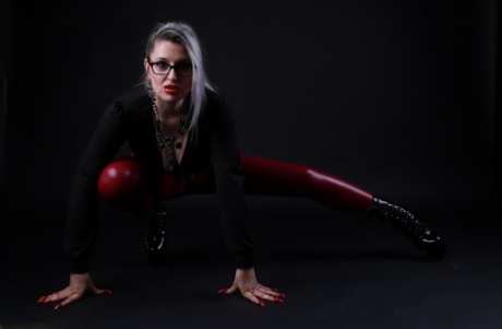 Platinum blonde Avengelique models in glasses while wearing latex pants