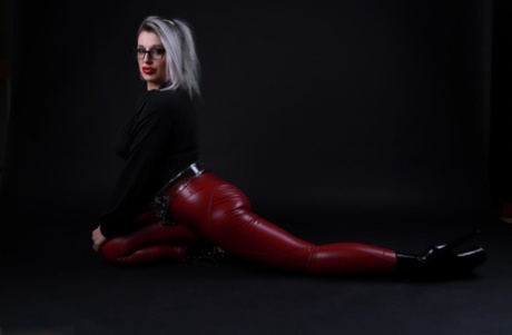 Platinum blonde Avengelique models in glasses while wearing latex pants