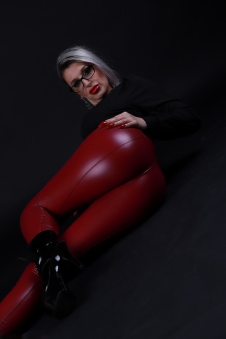 Platinum blonde Avengelique models in glasses while wearing latex pants