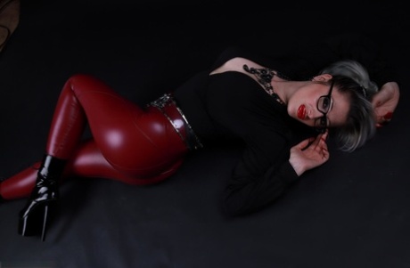 Platinum blonde Avengelique models in glasses while wearing latex pants