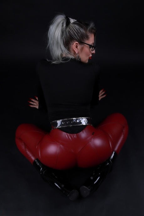 Platinum blonde Avengelique models in glasses while wearing latex pants