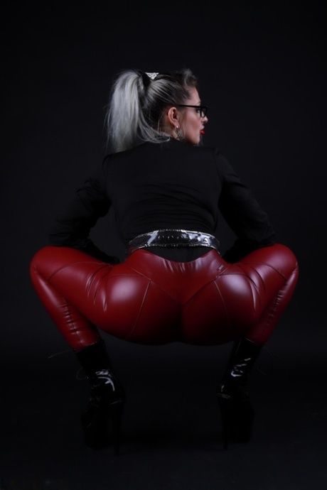 Platinum blonde Avengelique models in glasses while wearing latex pants