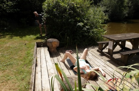 British chick Brook Logan gets naked on a dock while watching a man jack off