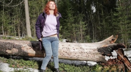 Natural redhead Nikky B takes a badly needed pee while out in the woods