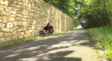 Pretty girl Aleya pulls down her pants to piss on a paved roadway