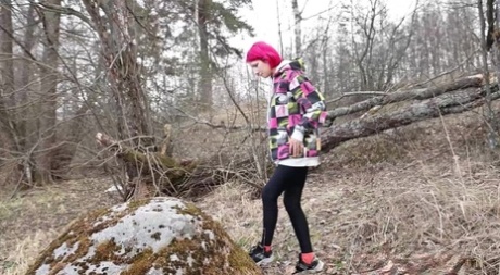 Solo girl with pink hair Vasya takes a badly needed pee over a boulder