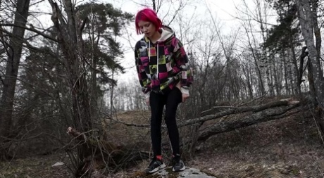 Solo girl with pink hair Vasya takes a badly needed pee over a boulder