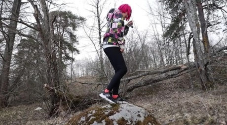 Solo girl with pink hair Vasya takes a badly needed pee over a boulder