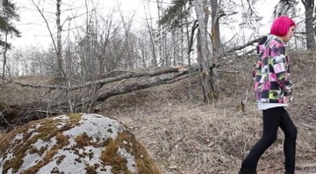 Solo girl with pink hair Vasya takes a badly needed pee over a boulder