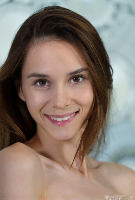 Sweet brunette teen Leona Mia takes off her dress to model in the nude
