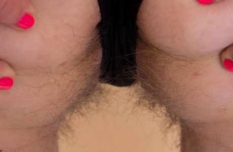 Dark haired amateur stretches out her hairy muff during a closeup