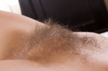 Dark haired amateur stretches out her hairy muff during a closeup