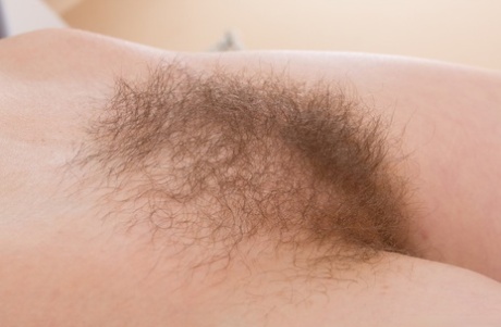 Dark haired amateur stretches out her hairy muff during a closeup