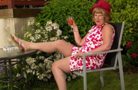Horny mature British woman in stockings masturbating in the garden