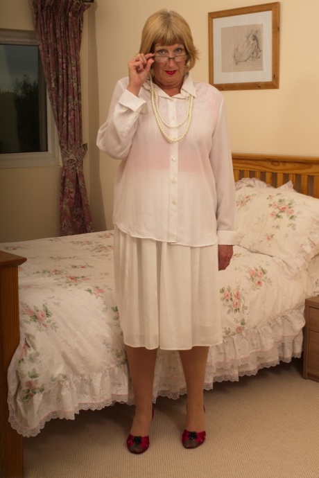 Horny old granny shyly removes her Sunday best to show her garter belt and ass