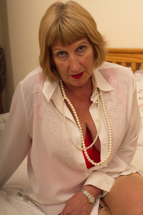 Horny old granny shyly removes her Sunday best to show her garter belt and ass