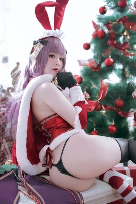 Purple haired Asian babe teases with her amazing curves in a Xmas outfit