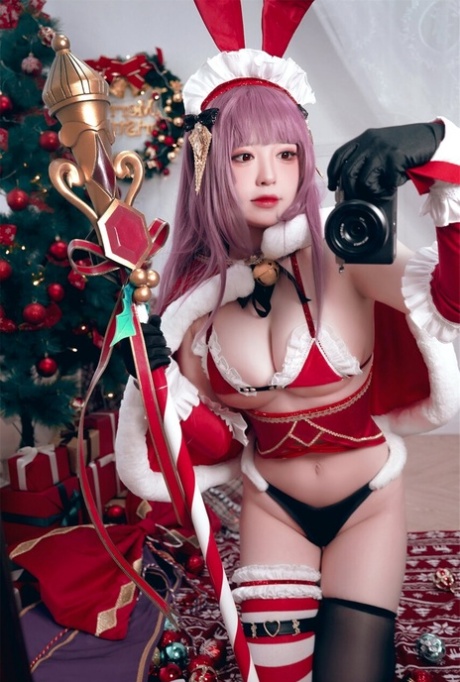 Purple haired Asian babe teases with her amazing curves in a Xmas outfit