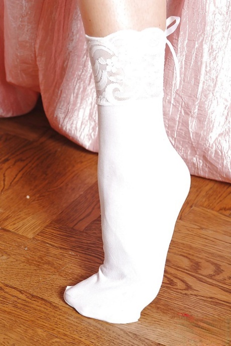 Desirable girl in lingerie and white socks revealing her curves and sexy feet