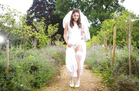 Newly married bride Carolina Abril posing outdoors in wedding dress