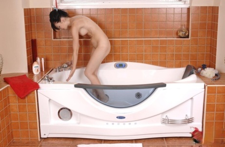 Brunette teen Timea Bela undresses before masturbating in tub with showerhead - pornpics.de