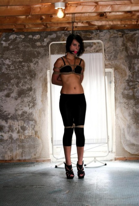 Dark haired female in spandex pants and a bra is left tied up and ball gagged - pornpics.de