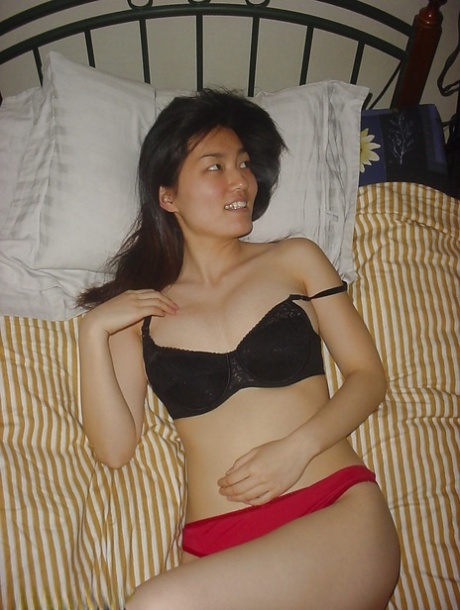 Seductive asian babe slipping off her clothes and showing off her big tits