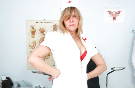 Raunchy mature lady in nurse uniform and stockings revealing her twat - pornpics.de