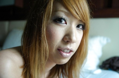 笑容满面、阴部多毛的亚洲少女 Mana Utsumi 在床上摆出裸体姿势