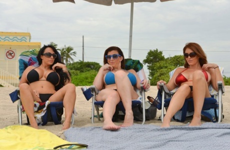 Three busty beach babes pull aside bikini tops to flaunt big tits by the water - pornpics.de