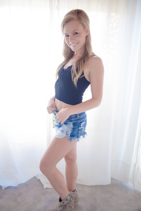 Blonde American girl Nicole Clitman slips jean shorts over her ass and twat