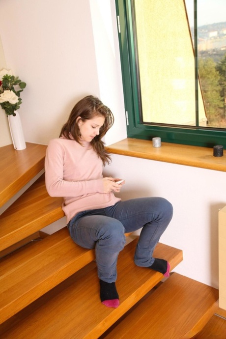 Teen Suzi D sits down on the stairs, nudes her pussy and rubs it with a finger