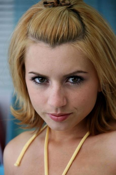 Sexy blonde Teenager Lexi Belle posiert solo auf dem Bett und stellt ihre natürlichen Titten zur Schau