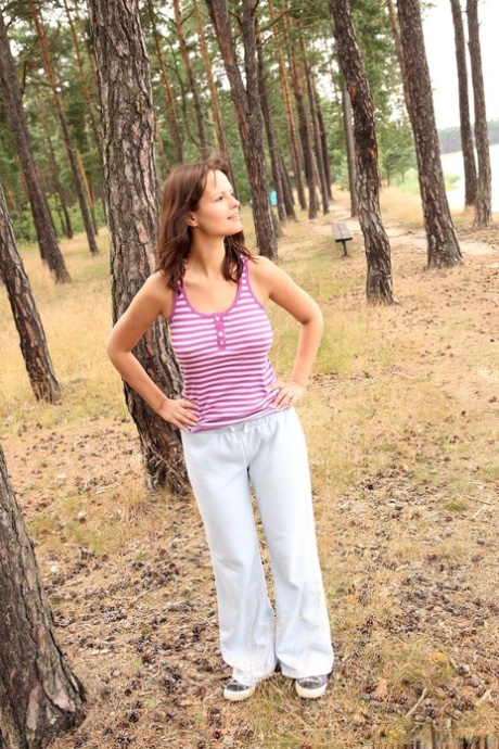 Brunette teen Rita E reveals her big boobs and rubs her muff in the woods
